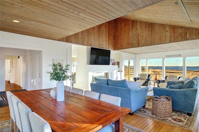 dining area featuring high vaulted ceiling, hardwood / wood-style floors, and wooden ceiling