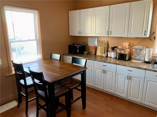 kitchen featuring white cabinetry and light hardwood / wood-style flooring