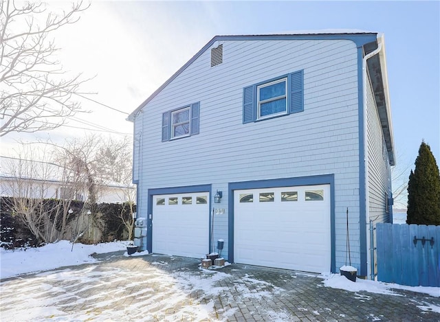 view of snowy exterior with a garage