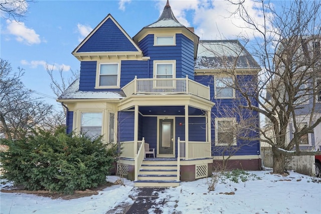 victorian house featuring a balcony and a porch