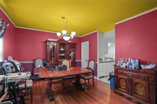 dining room featuring crown molding, hardwood / wood-style floors, and a notable chandelier