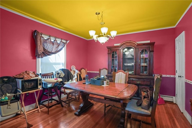 dining room featuring a baseboard heating unit, ornamental molding, dark hardwood / wood-style floors, and a chandelier