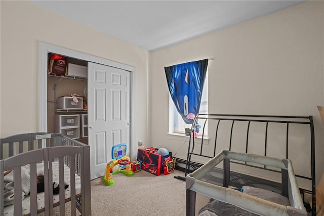 bedroom featuring a closet, a nursery area, and carpet flooring