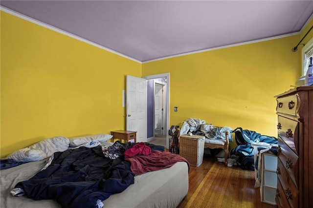 bedroom with crown molding and dark hardwood / wood-style floors