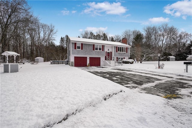 raised ranch with a storage shed and a garage