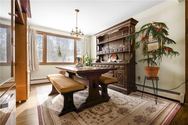 dining area featuring a baseboard radiator, a chandelier, and light hardwood / wood-style floors