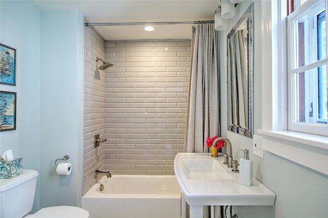 full bathroom with sink, shower / tub combo with curtain, and toilet