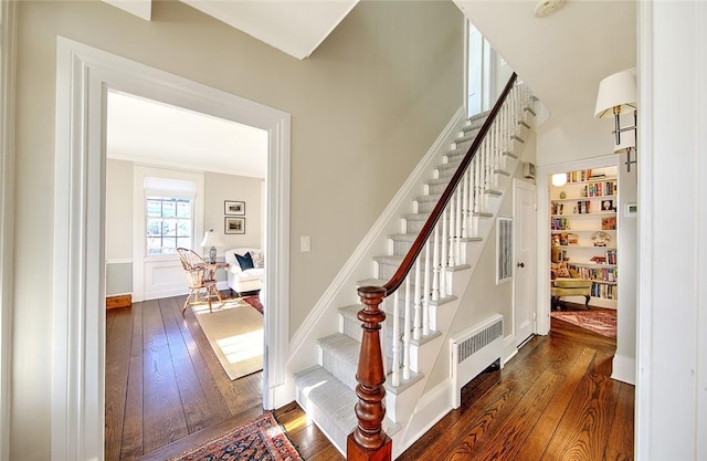 stairs featuring radiator and wood-type flooring