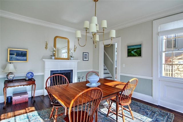 dining area with dark wood-type flooring, ornamental molding, a chandelier, and a healthy amount of sunlight