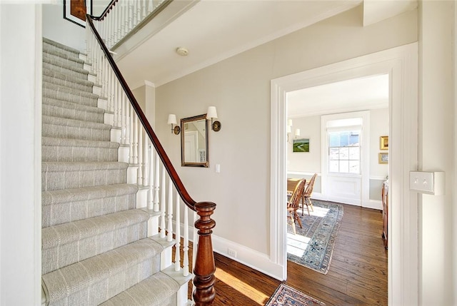 staircase with crown molding and hardwood / wood-style flooring