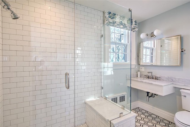 bathroom with tile patterned flooring, an enclosed shower, and toilet