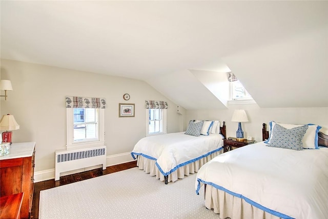 bedroom with vaulted ceiling, radiator, and dark hardwood / wood-style flooring