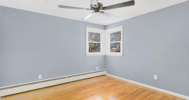 spare room featuring a baseboard radiator, wood-type flooring, and ceiling fan