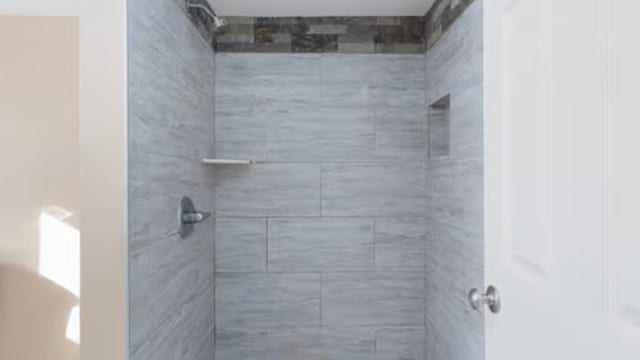 bathroom with a tile shower