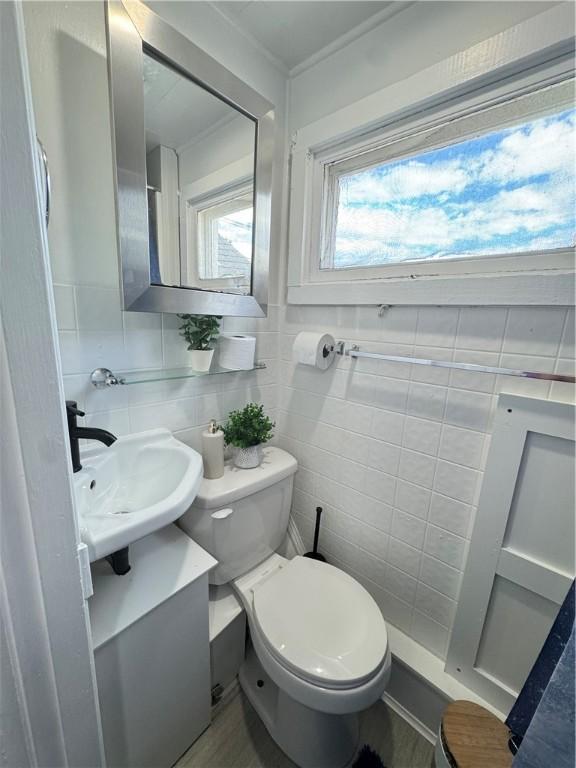 bathroom featuring decorative backsplash, vanity, toilet, and tile walls