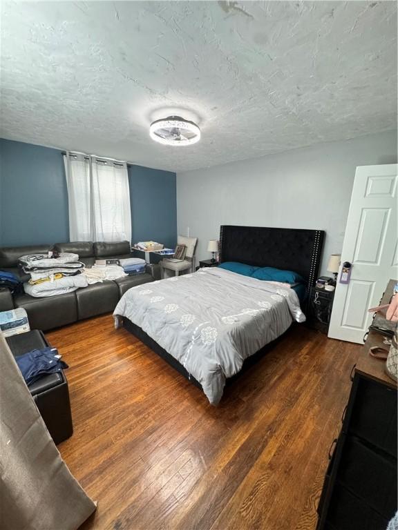 bedroom featuring dark wood-type flooring and a textured ceiling