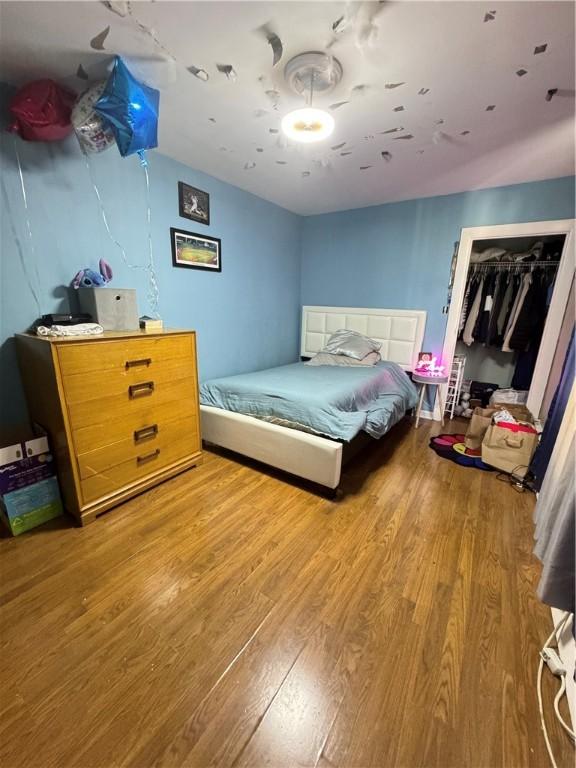 bedroom with wood-type flooring and a closet