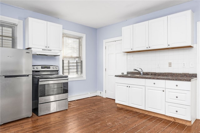 kitchen featuring baseboard heating, white cabinetry, stainless steel appliances, dark hardwood / wood-style floors, and decorative backsplash