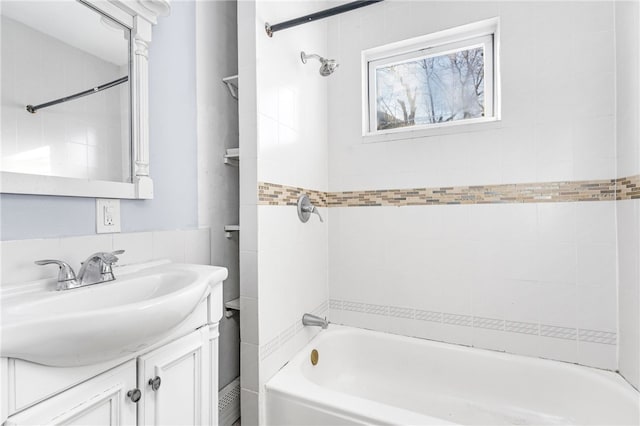 bathroom with tiled shower / bath combo and vanity