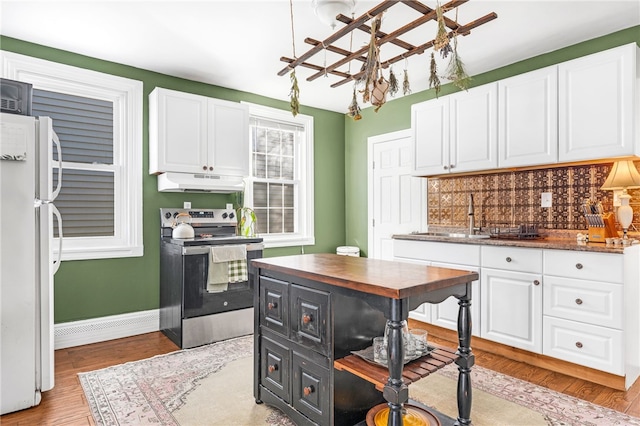 kitchen with sink, tasteful backsplash, stainless steel electric range oven, white fridge, and white cabinets