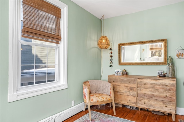 sitting room featuring a baseboard heating unit and hardwood / wood-style floors