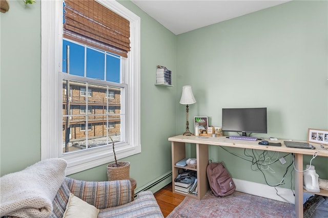 office with a baseboard heating unit and hardwood / wood-style flooring