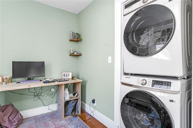 laundry area with hardwood / wood-style flooring and stacked washing maching and dryer