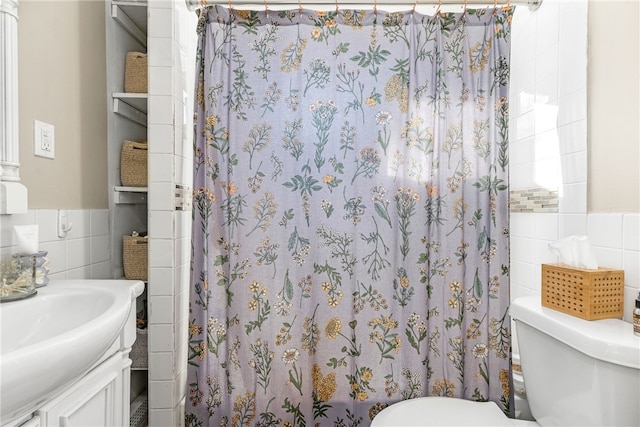 bathroom featuring a shower with curtain, vanity, toilet, and tile walls