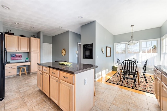 kitchen featuring light brown cabinetry, light tile patterned floors, and a center island