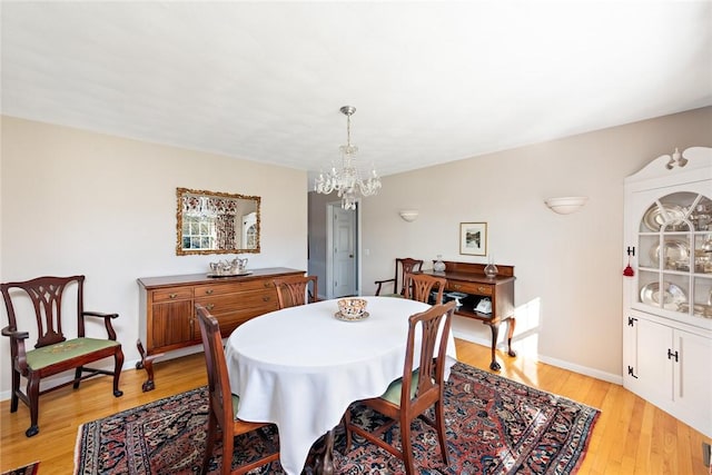 dining room featuring light hardwood / wood-style flooring and a chandelier