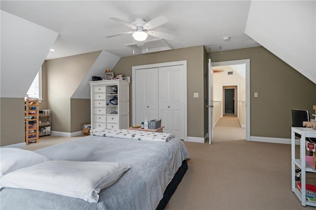 bedroom featuring light carpet, lofted ceiling, a closet, and ceiling fan