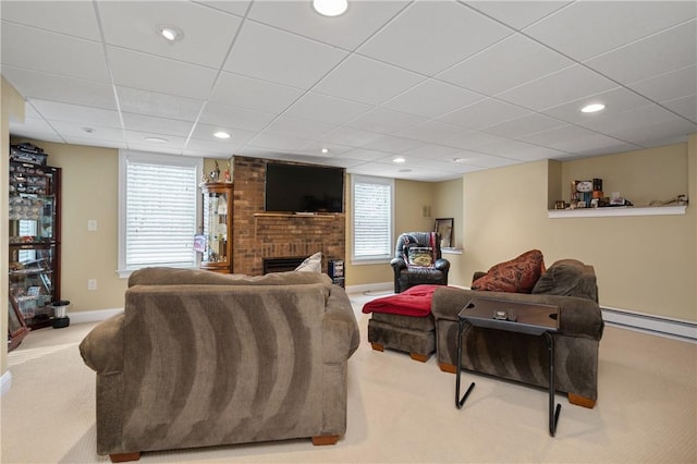 living room featuring baseboard heating, light colored carpet, a healthy amount of sunlight, and a fireplace