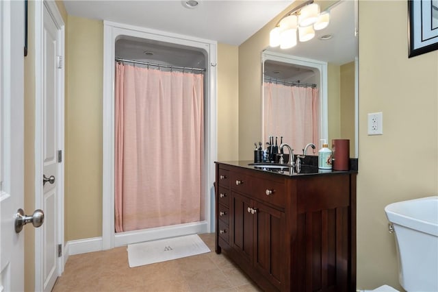 bathroom featuring a shower with curtain, vanity, tile patterned floors, and toilet