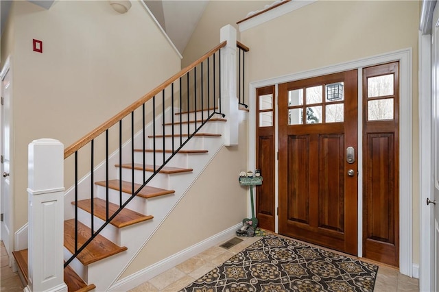 foyer entrance featuring vaulted ceiling and light tile patterned flooring