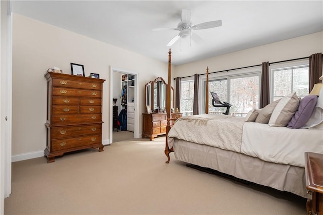 bedroom featuring ceiling fan, a spacious closet, light colored carpet, and a closet