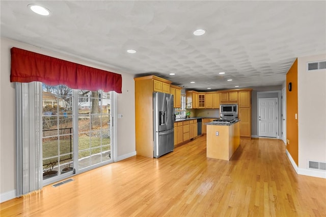 kitchen featuring a kitchen island, appliances with stainless steel finishes, and light hardwood / wood-style floors