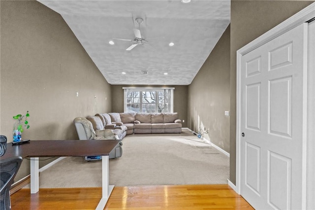 living room featuring ceiling fan, carpet flooring, and vaulted ceiling