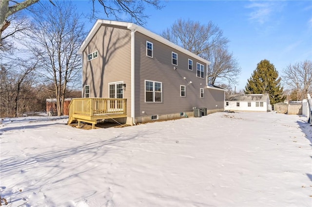 snow covered rear of property with a wooden deck and central air condition unit