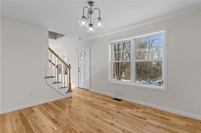 entrance foyer with a notable chandelier and light wood-type flooring