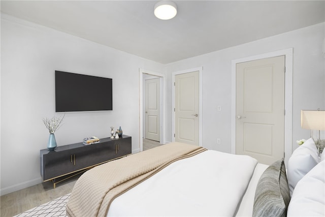 bedroom with light wood-type flooring and baseboards