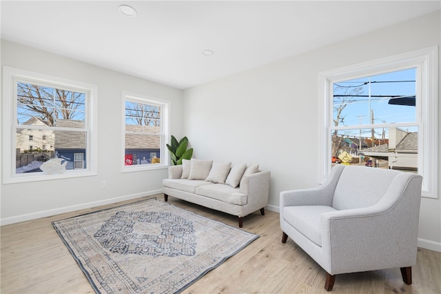 living area with light wood-style flooring and baseboards