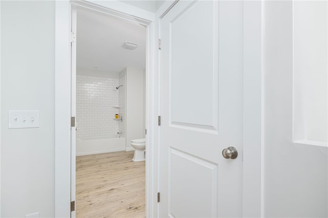 full bathroom with toilet, wood finished floors, and bathing tub / shower combination