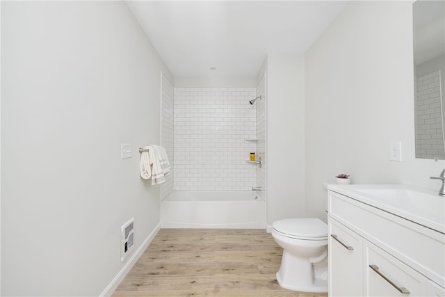 bathroom featuring toilet, washtub / shower combination, vanity, wood finished floors, and baseboards