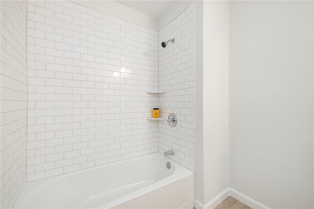 bathroom featuring shower / bath combination and baseboards