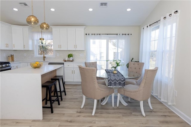 kitchen featuring pendant lighting, white cabinetry, backsplash, a kitchen island, and vaulted ceiling