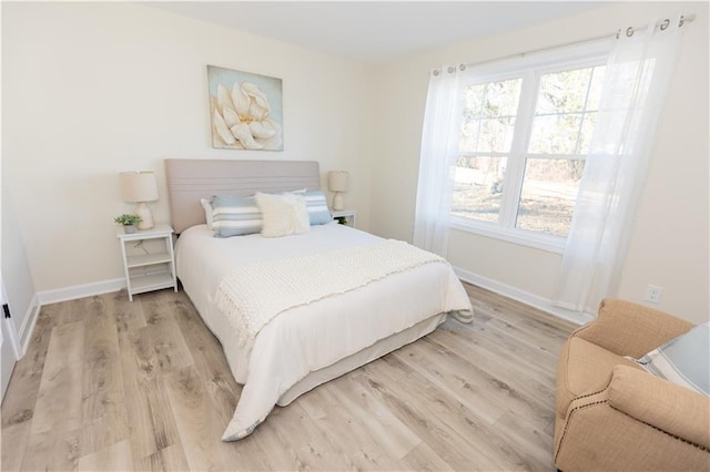 bedroom featuring multiple windows and light hardwood / wood-style flooring