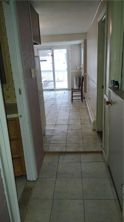 hall featuring light tile patterned flooring and baseboard heating