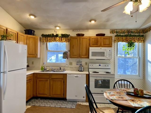 kitchen featuring lofted ceiling, sink, white appliances, and ceiling fan