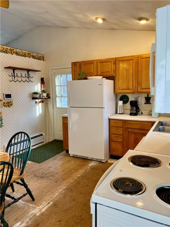 kitchen featuring white appliances and vaulted ceiling