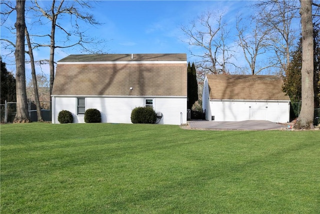 view of side of property featuring an outbuilding, a patio, and a lawn